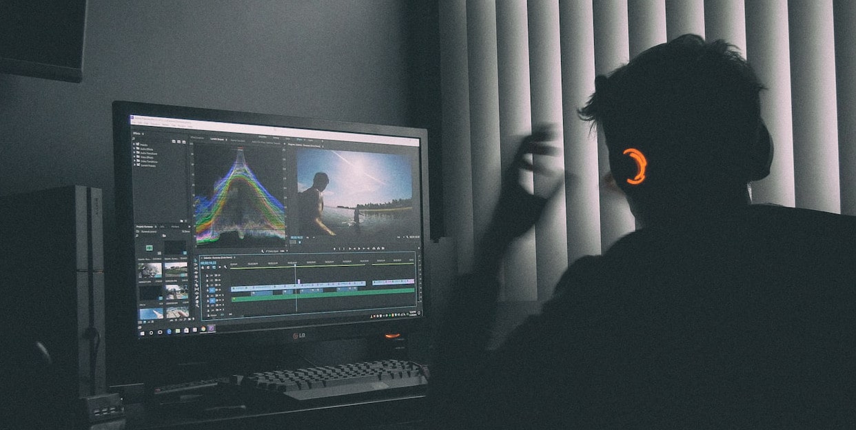 Male editing video behind the computer